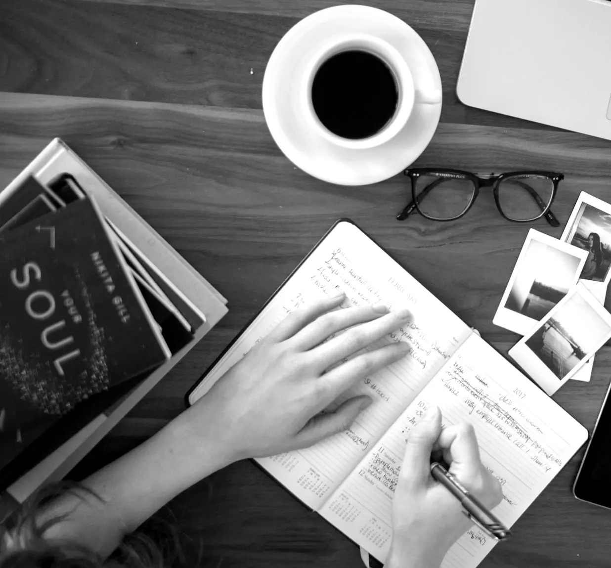 person holding ballpoint pen writing on notebook